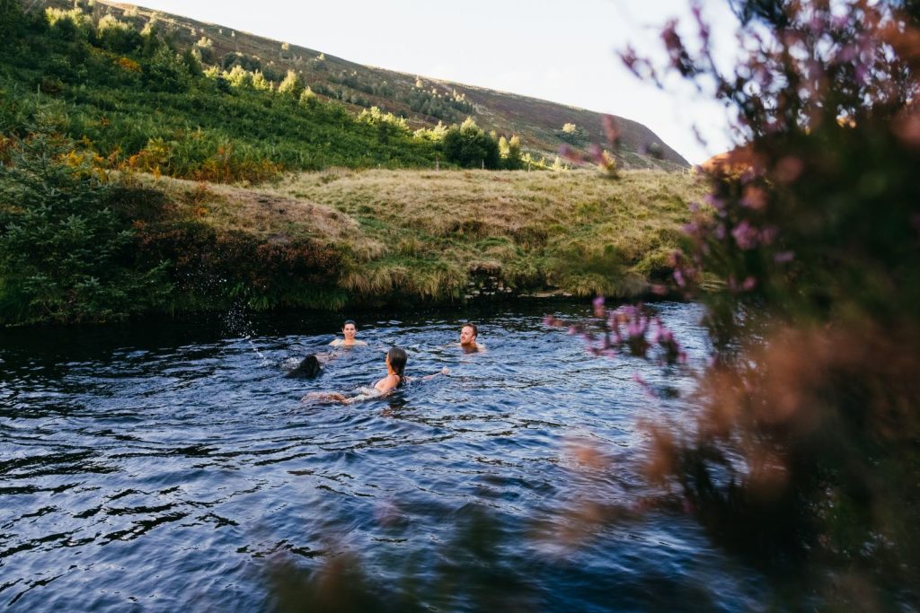 family swimming in a wild glen in Scotland
