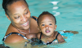 Mother holding her baby in a swimming pool during a lesson